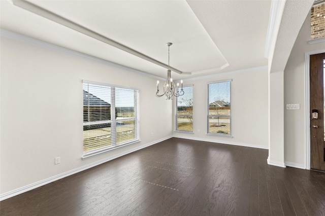 unfurnished room featuring a chandelier, ornamental molding, dark hardwood / wood-style flooring, and a tray ceiling