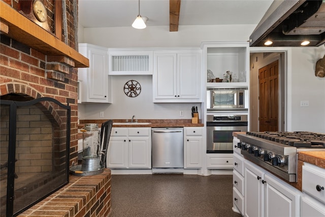 kitchen with appliances with stainless steel finishes, white cabinetry, custom exhaust hood, and pendant lighting