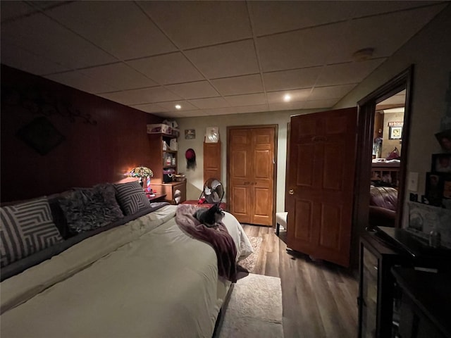 bedroom featuring light hardwood / wood-style flooring and a drop ceiling