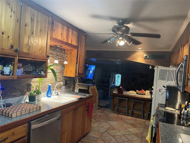 kitchen featuring appliances with stainless steel finishes, tasteful backsplash, ceiling fan, and ornamental molding