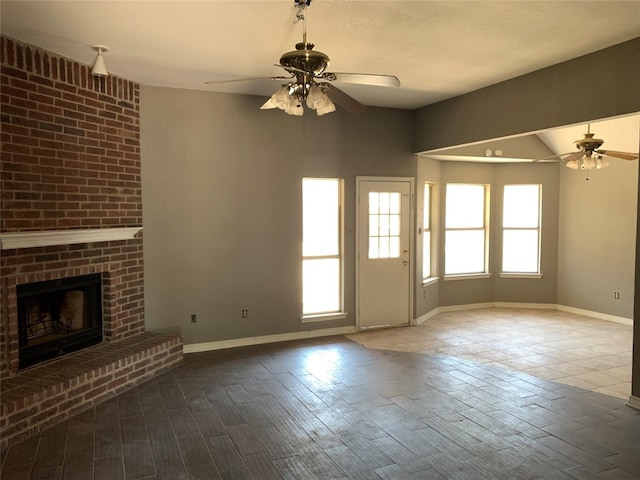 unfurnished living room with lofted ceiling, a fireplace, ceiling fan, and hardwood / wood-style floors