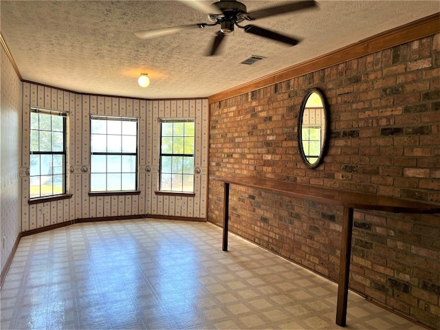 spare room featuring light tile flooring, ceiling fan, wood walls, a textured ceiling, and brick wall