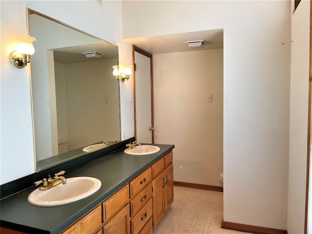 bathroom featuring double sink, oversized vanity, tile flooring, and toilet