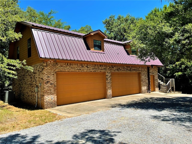 view of front facade featuring central AC unit and a garage