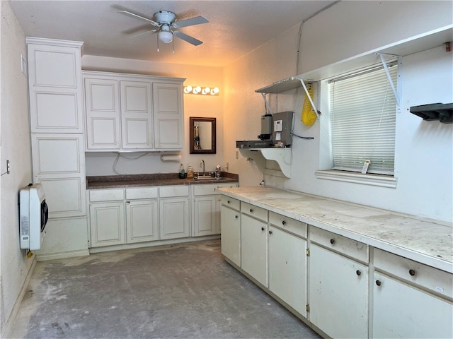 kitchen featuring white cabinets, concrete floors, ceiling fan, and sink