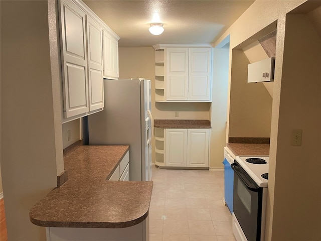 kitchen with white cabinets, light tile flooring, white appliances, and a textured ceiling