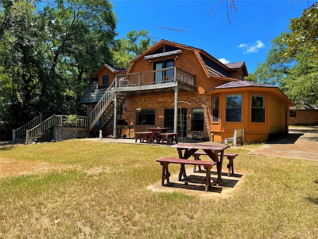 rear view of house featuring a lawn, a deck, and a patio area