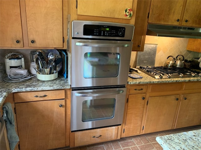 kitchen featuring tasteful backsplash, stainless steel appliances, and light stone counters