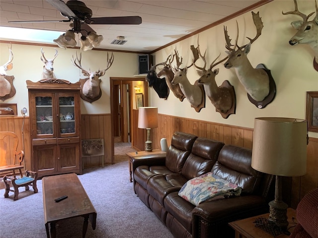 living room with crown molding, carpet floors, and ceiling fan