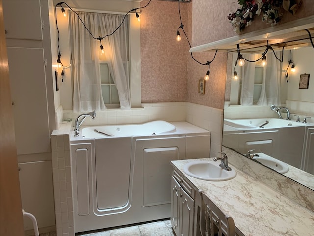 bathroom with tile flooring, vanity, and a bath