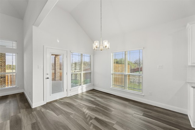 interior space with an inviting chandelier, high vaulted ceiling, a wealth of natural light, and dark hardwood / wood-style flooring