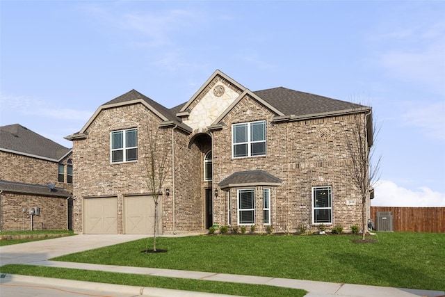 front of property with central AC unit, a front lawn, and a garage