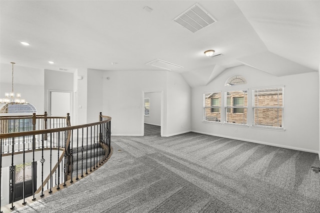 interior space with lofted ceiling, dark colored carpet, and a chandelier