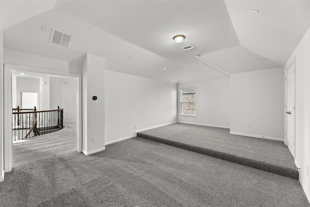 bonus room featuring dark carpet and vaulted ceiling