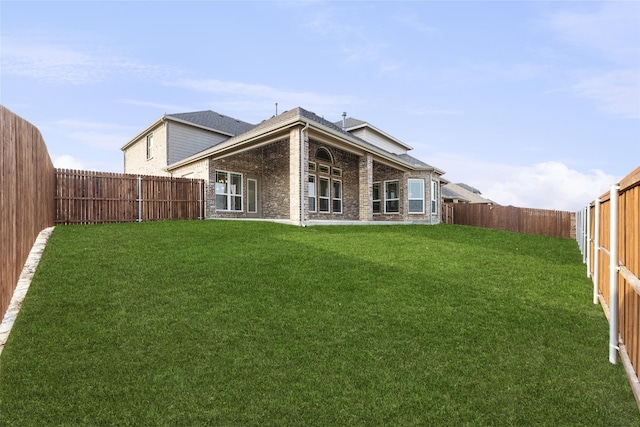 rear view of property featuring a yard