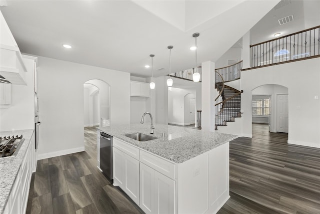 kitchen featuring white cabinets, dark hardwood / wood-style flooring, a kitchen island with sink, and sink