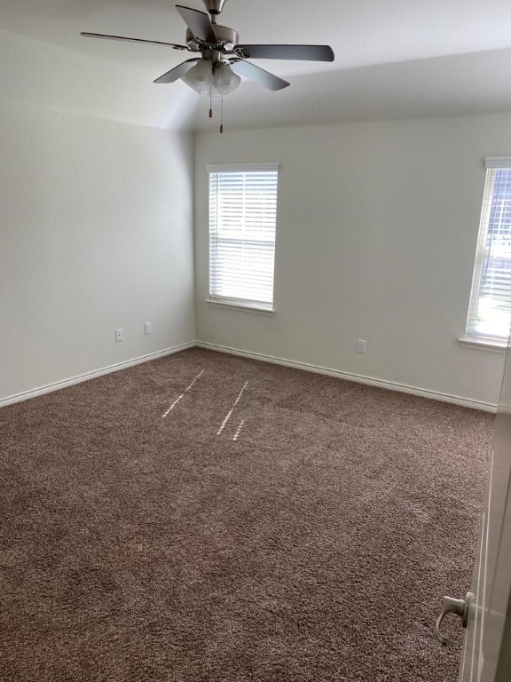 unfurnished room with plenty of natural light, ceiling fan, and carpet floors