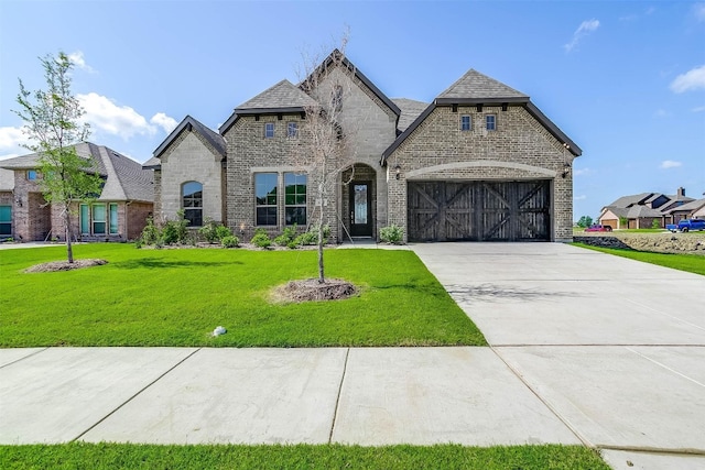 french country inspired facade with a front lawn and a garage