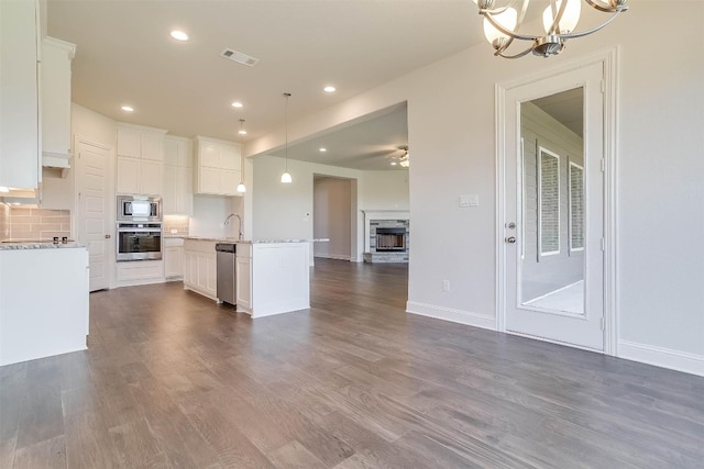 kitchen featuring pendant lighting, dark hardwood / wood-style floors, a fireplace, and appliances with stainless steel finishes