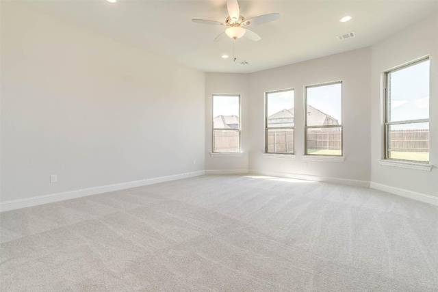 carpeted spare room featuring ceiling fan