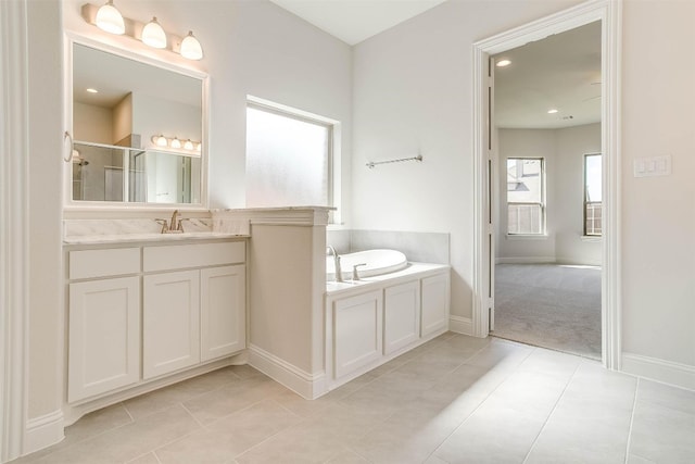 bathroom with a bathtub, vanity, and tile floors