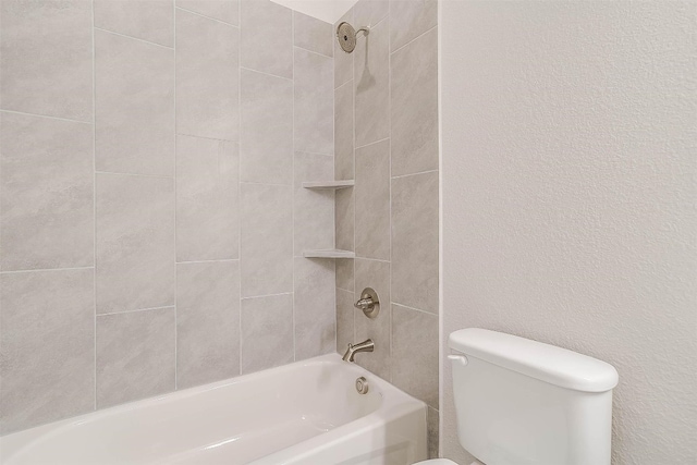 bathroom featuring tiled shower / bath combo and toilet