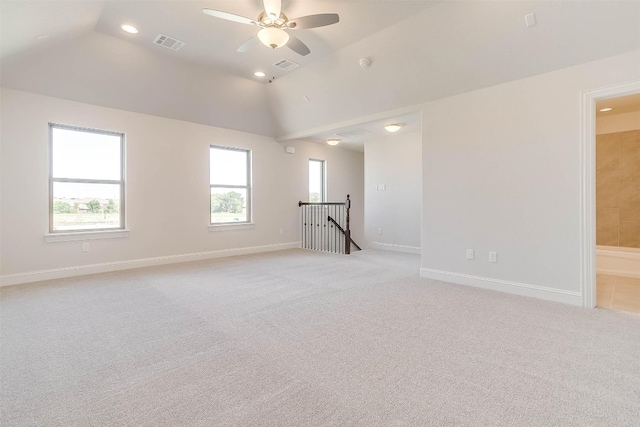 carpeted spare room with ceiling fan and vaulted ceiling