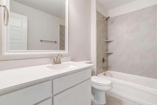 full bathroom with tiled shower / bath, toilet, tile flooring, and vanity