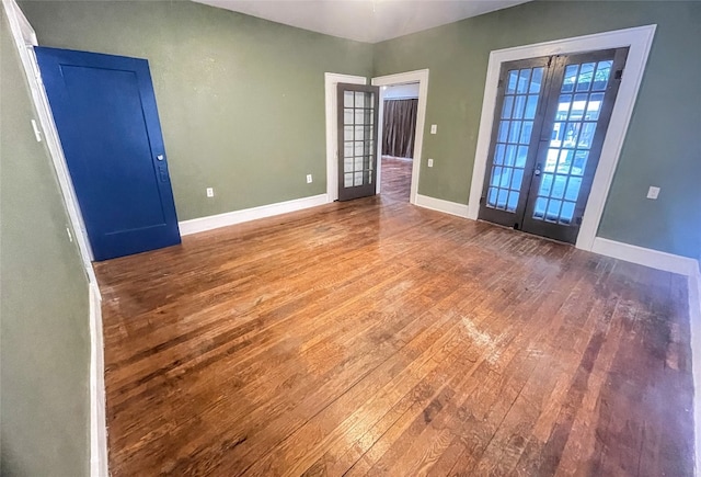 spare room featuring hardwood / wood-style flooring and french doors