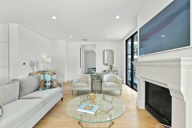 living room featuring floor to ceiling windows and light hardwood / wood-style floors