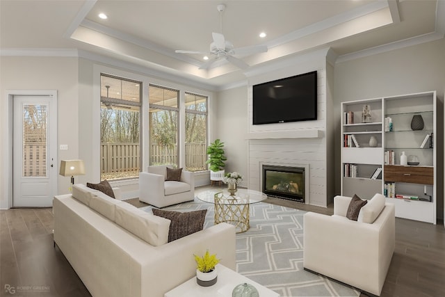 living room with ceiling fan, crown molding, dark hardwood / wood-style floors, and a tray ceiling