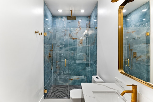 bathroom featuring toilet, vanity, and a shower with shower door