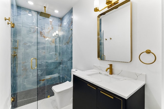 bathroom featuring a shower with shower door, toilet, and large vanity