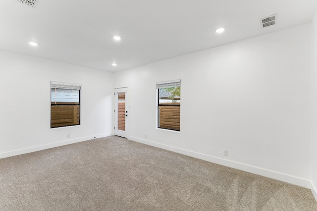 spare room featuring light carpet