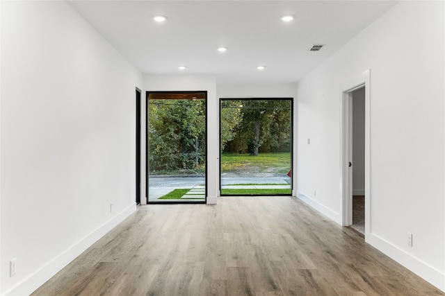 unfurnished room featuring a healthy amount of sunlight and light wood-type flooring