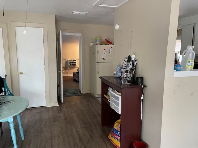 hallway with dark hardwood / wood-style floors and a wall unit AC