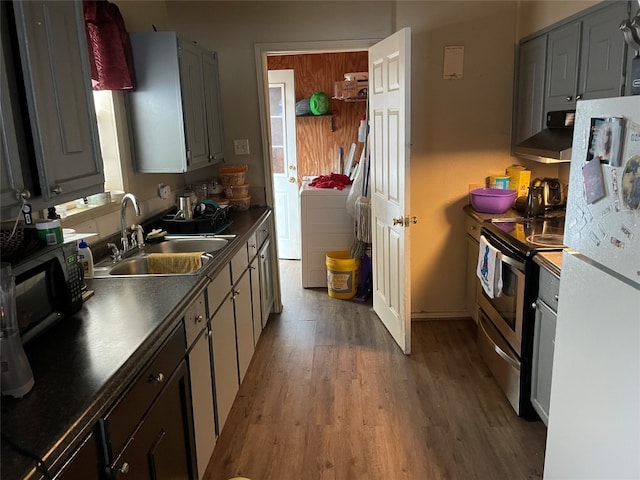 kitchen with white fridge, wall chimney range hood, hardwood / wood-style floors, stainless steel electric range, and sink