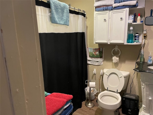 bathroom with hardwood / wood-style flooring and toilet