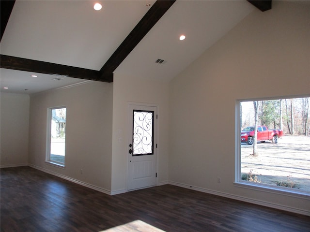 foyer with dark hardwood / wood-style flooring, a wealth of natural light, and beamed ceiling