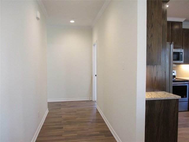 hallway with dark hardwood / wood-style floors and crown molding