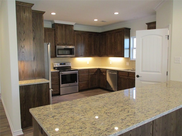 kitchen featuring dark hardwood / wood-style floors, stainless steel appliances, dark brown cabinets, and light stone counters