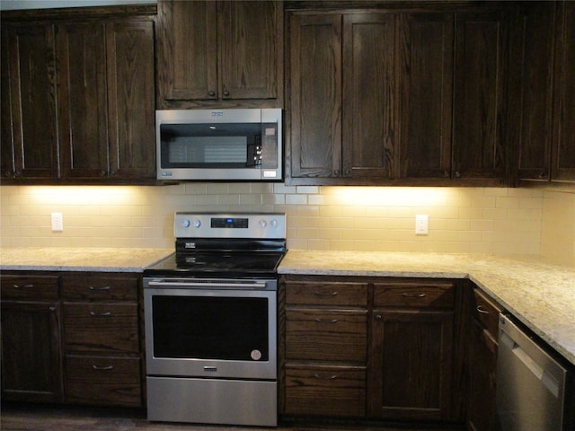 kitchen featuring light stone countertops, tasteful backsplash, dark brown cabinets, and appliances with stainless steel finishes