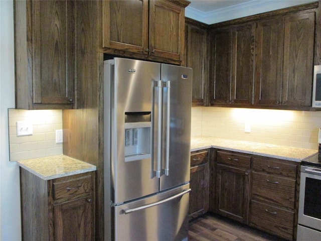 kitchen with dark brown cabinets, appliances with stainless steel finishes, backsplash, and dark hardwood / wood-style floors