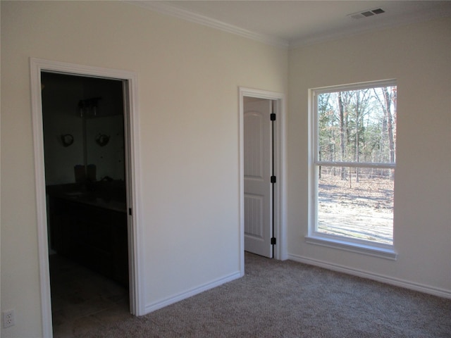 unfurnished bedroom with light carpet, multiple windows, a spacious closet, and crown molding