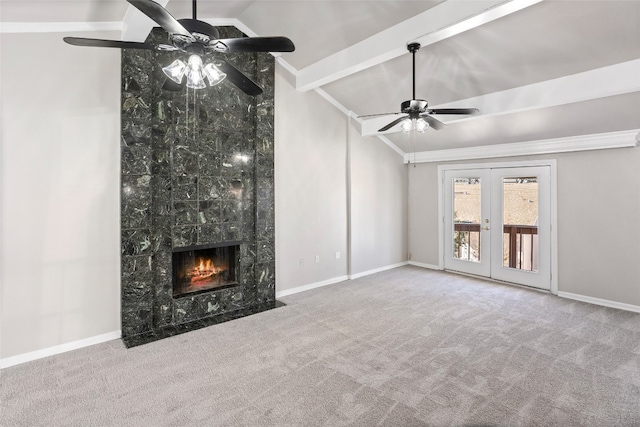 unfurnished living room featuring a premium fireplace, french doors, lofted ceiling with beams, light colored carpet, and ceiling fan