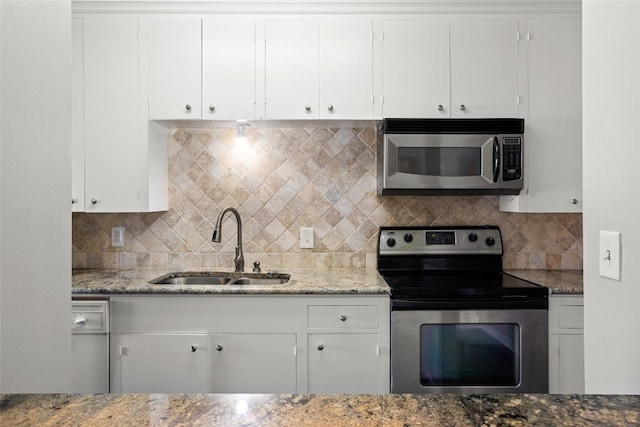 kitchen with stainless steel appliances, decorative backsplash, white cabinetry, and sink