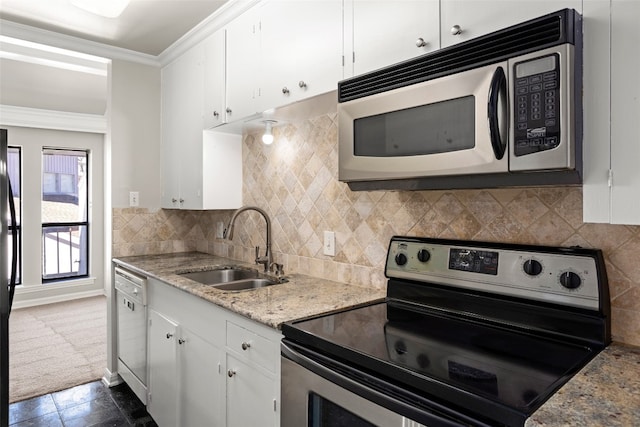 kitchen featuring appliances with stainless steel finishes, light stone countertops, white cabinetry, sink, and tasteful backsplash