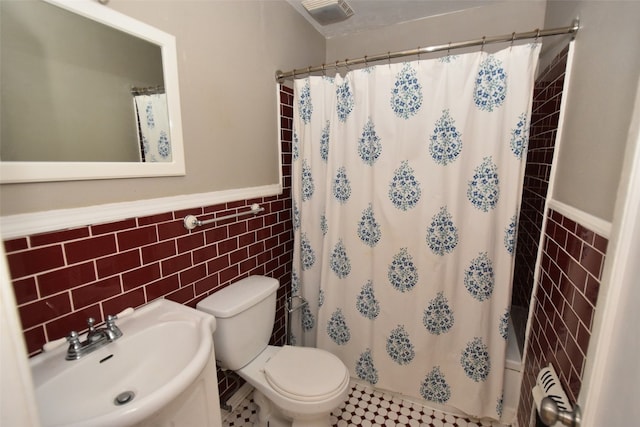 bathroom featuring tile walls, toilet, backsplash, and tile flooring