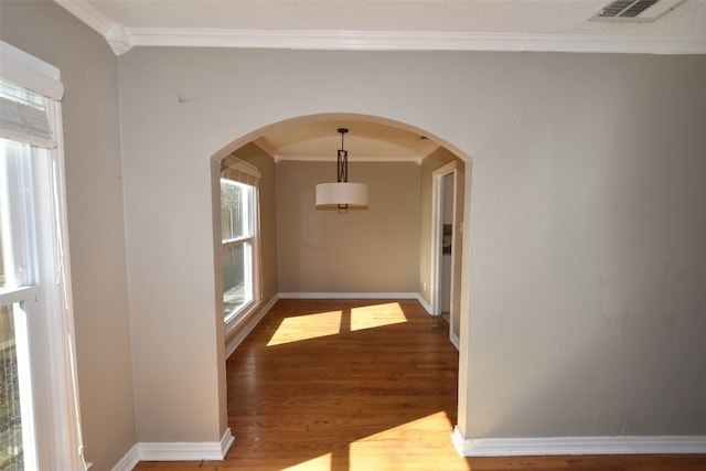 hallway featuring plenty of natural light, crown molding, and hardwood / wood-style flooring