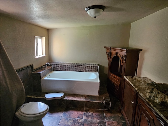 bathroom featuring a bathing tub, vanity, toilet, and tile floors